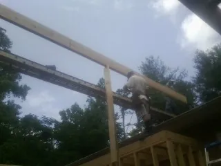Carpenter setting a ridge beam over a new addition frame — Ice Dam Removal by Roofing Brothers in East Brunswick