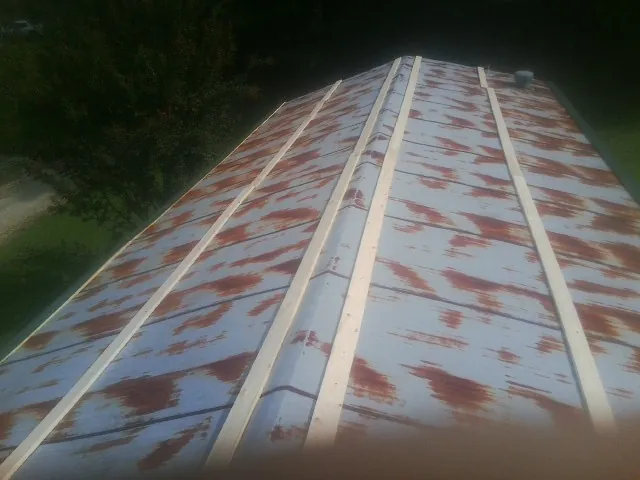 Rusted metal roof panels with new wood purlins before replacement — Storm Damage Roof Repair in East Brunswick by Roofing Brothers