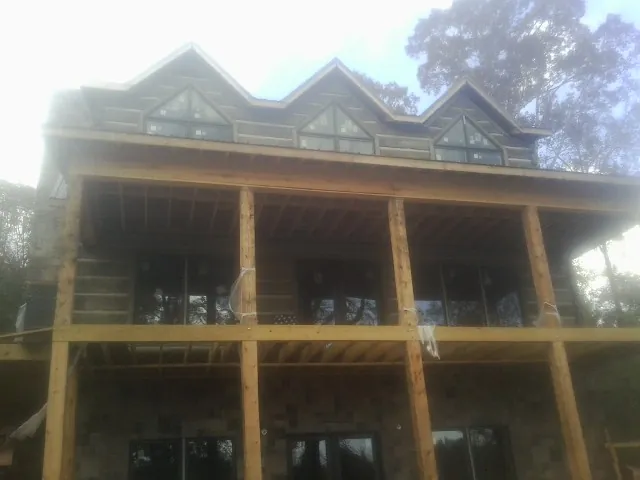 Dormers and porch framing on a large log home under construction — Roof Coating work by our crew in East Brunswick