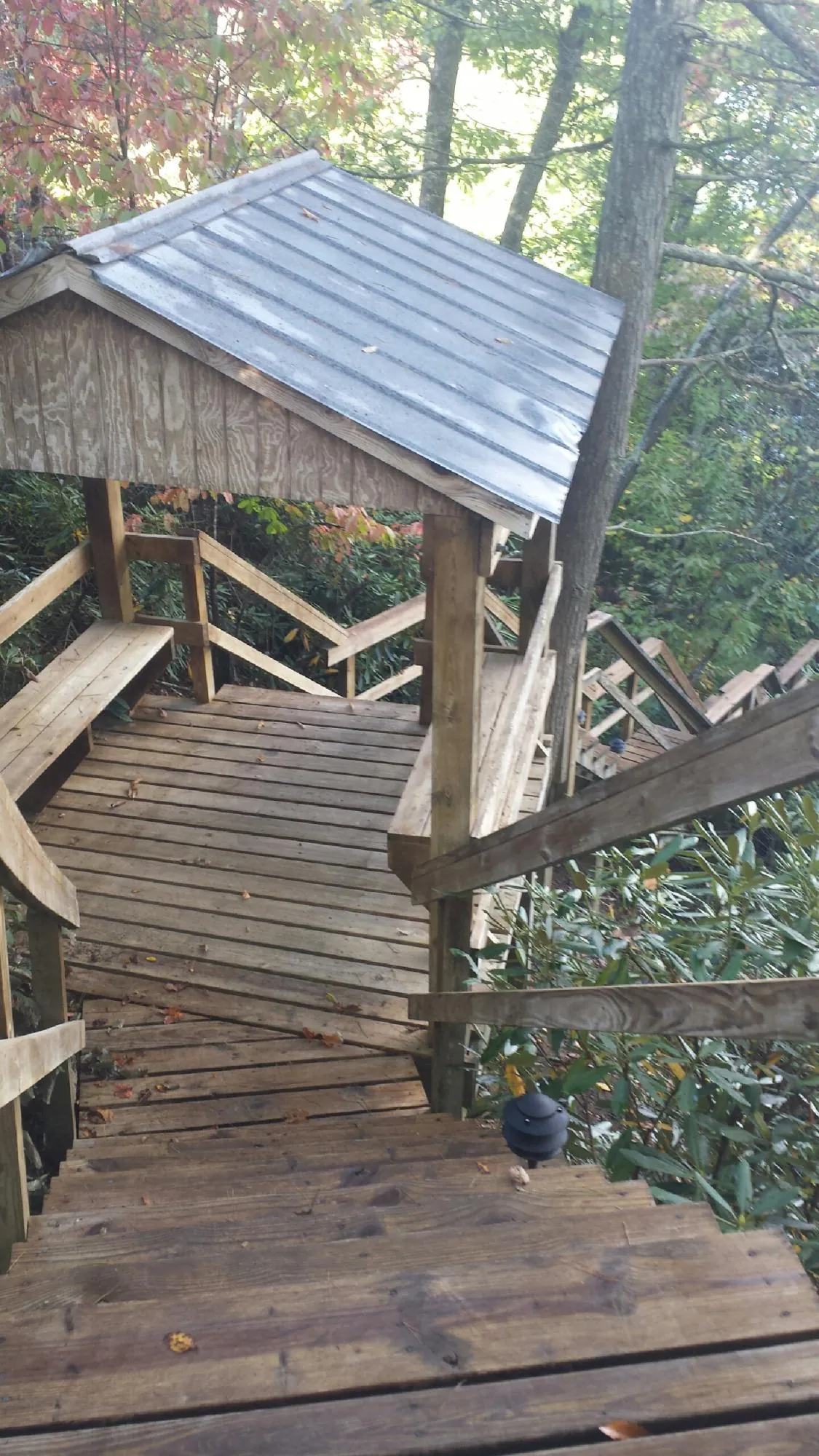 Metal roofed shelter over wooden steps on a wooded walkway — Skylight Repair & Installation work by our crew in East Brunswick