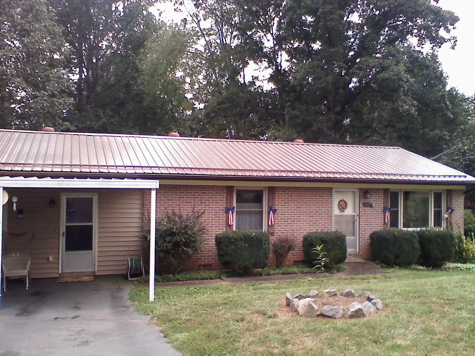 Bronze metal roof and carport on a brick ranch home — Roof Repair work by our crew in East Brunswick